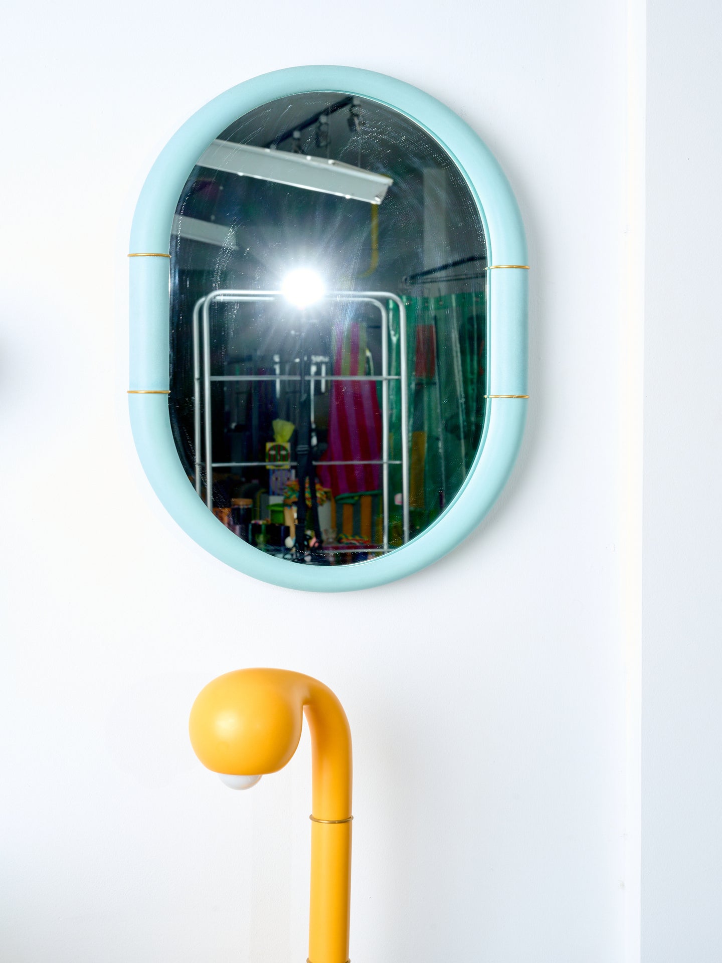 Ceramic Mirror in blue hung above a tangerine ceramic table lamp.