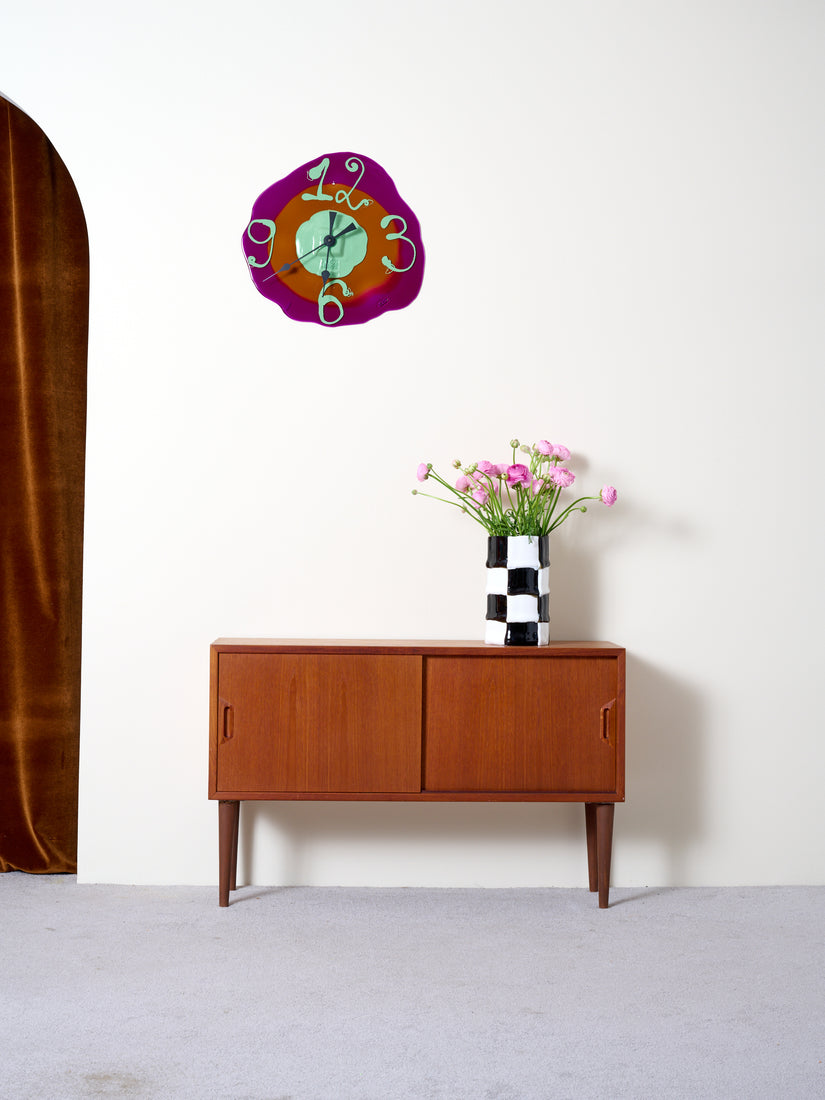 Vintage Sideboard against a white wall with a Jumbo Bamboo Vase atop and a Watch Me Clock hung on the wall above.