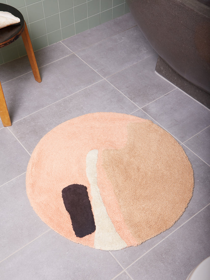The Crop Circles Bath Mat by Cold Picnic on grey tile.