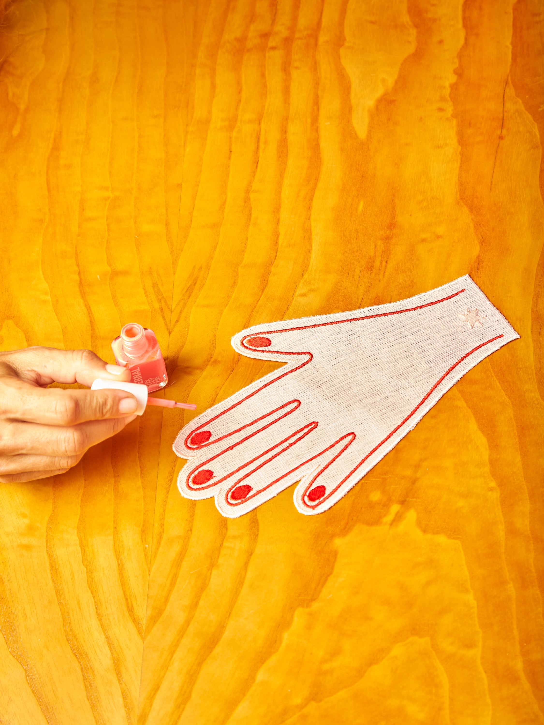 A hand pretending to paint the nail of a cocktail napkin.