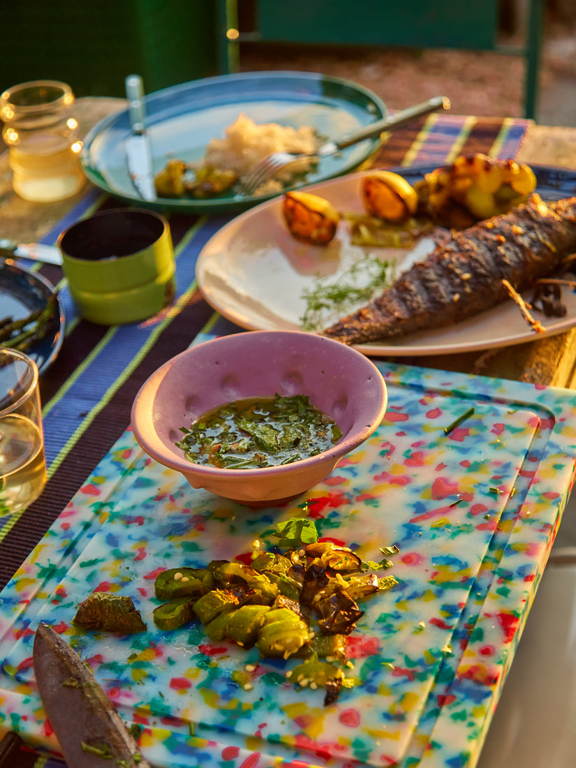 A dinner table full of different foods highlighting the lilac dimpled ceramic bowl.