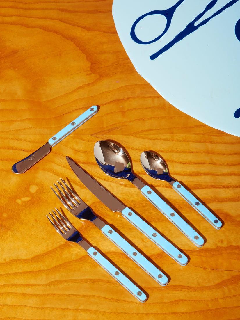 A place setting of Sabre bistro flatware in blue.
