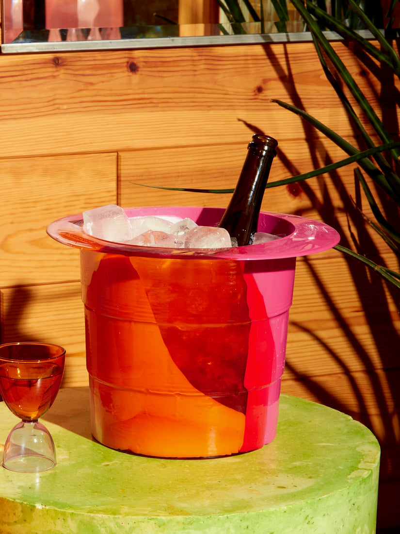 Babel Ice Bucket in Pink Orange by Gaetano Pesce for Fish Design full of ice and an open wine bottle.