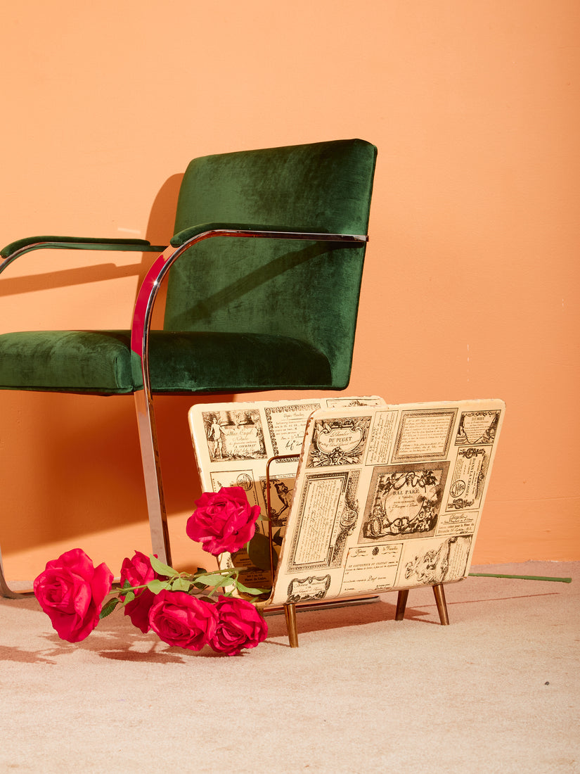 Vintage Fornasetti Magazine rack paired with a green Brno chair.
