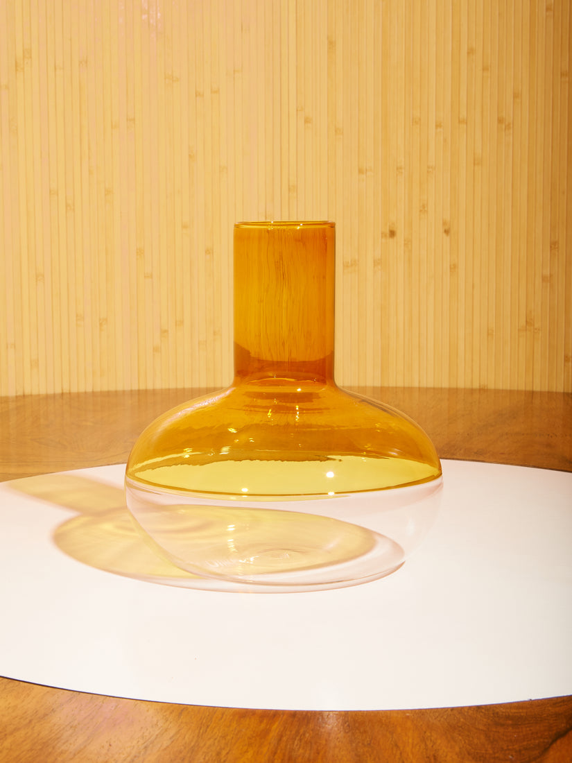 The Alchemy Wine Decanter sits atop a dining table by Milo Baughman with a wooden slat backdrop.