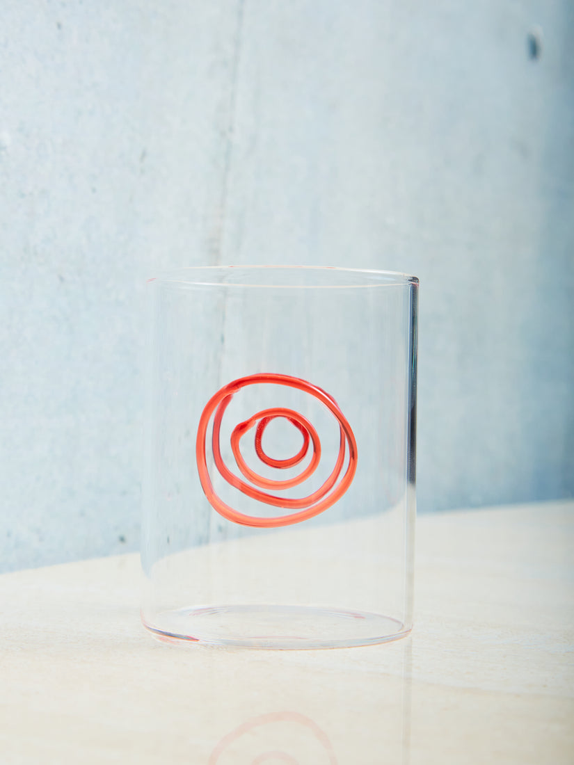 A clear glass with red donut flame worked shape.