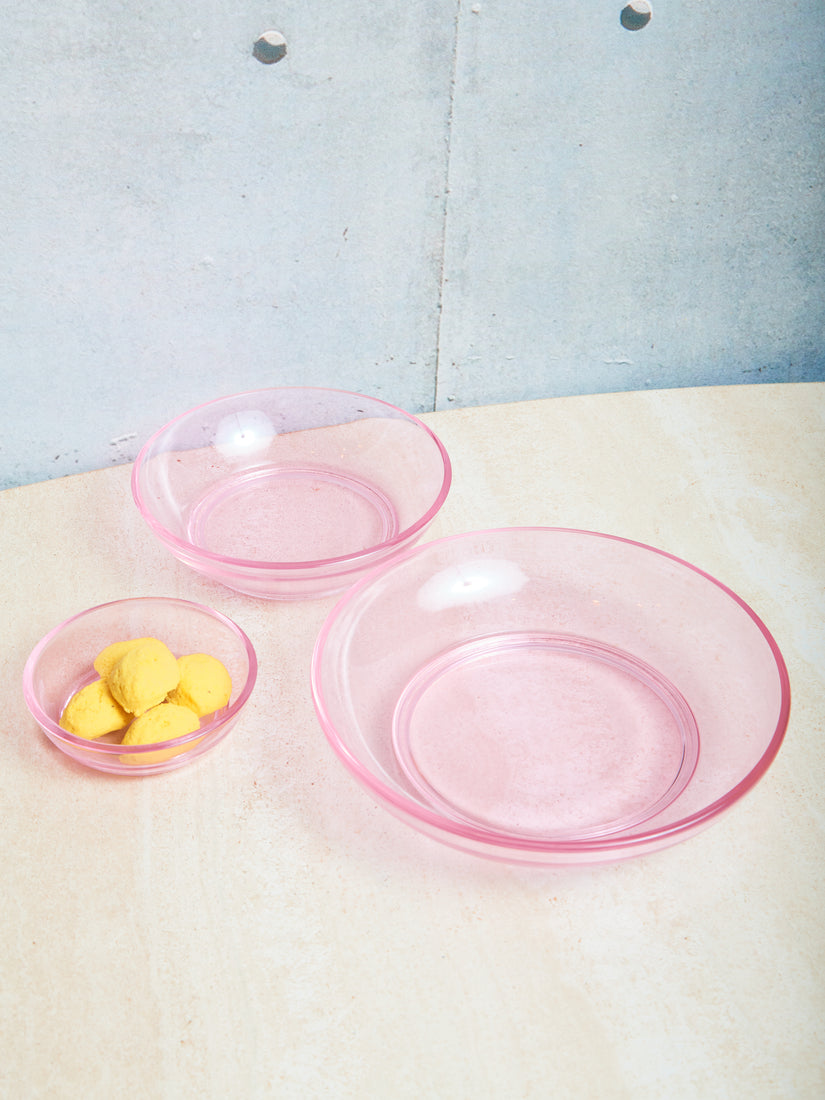 Transparent pink glass bowls in 3 different sizes.