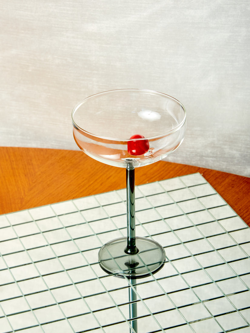 A Manhattan stemmed glass with red glass cherry inside. 
