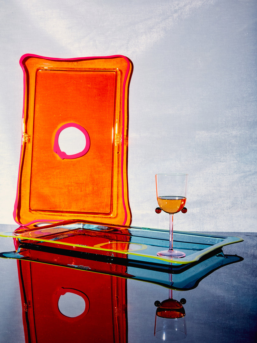 Large rectangular trays by Gaetano Pesce for Fish Design in Orange/Fuchsia and Blue/Lime. A Pompom Wine Glass rests on the blue tray while the orange tray is leaned standing up.