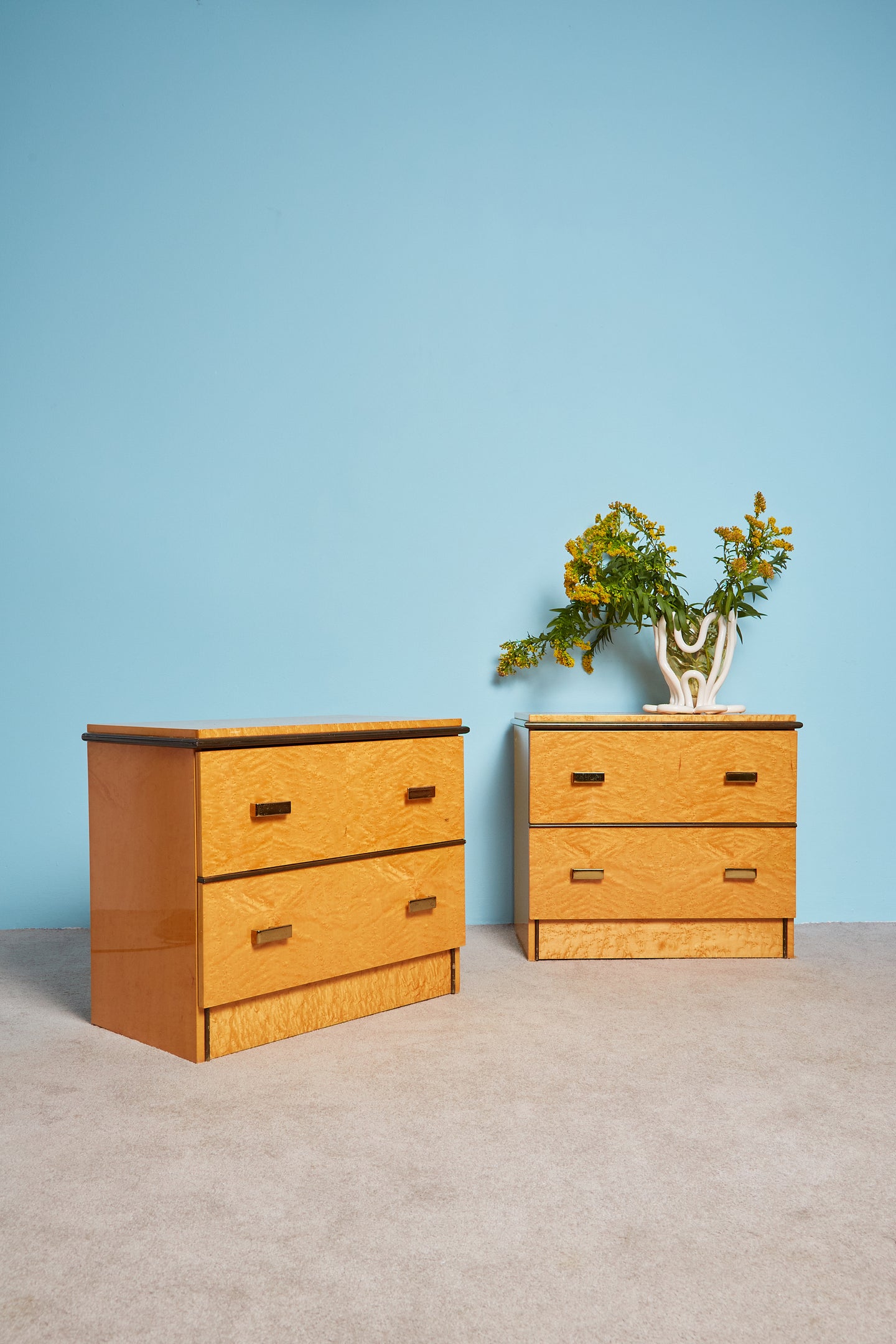 Nightstands with brass hardware and dark wood accents.