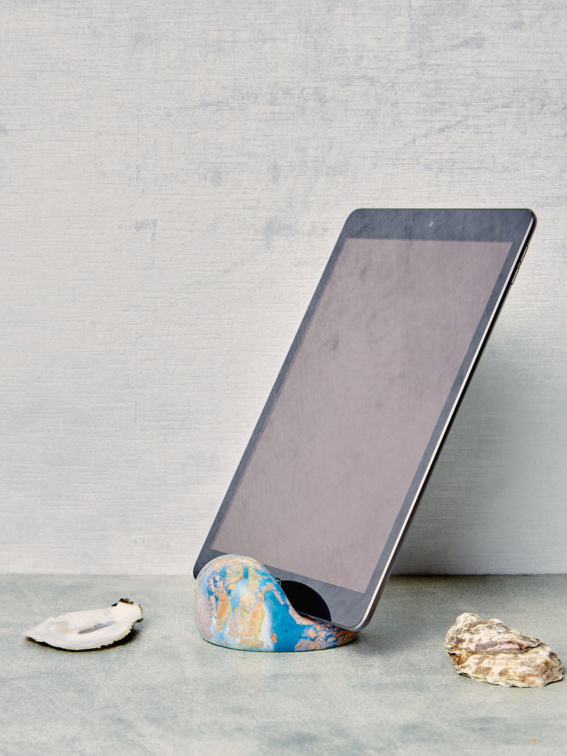 An IPad rests inside a blue multicolor bloop stands.