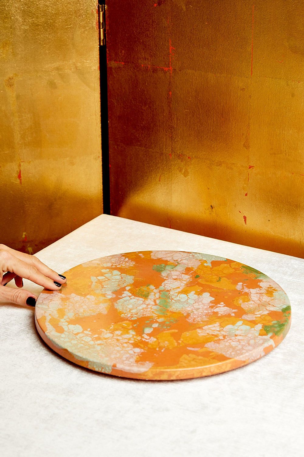 Mostly orange Concrete Lazy Susan with pattern of creams, pinks, and greens.