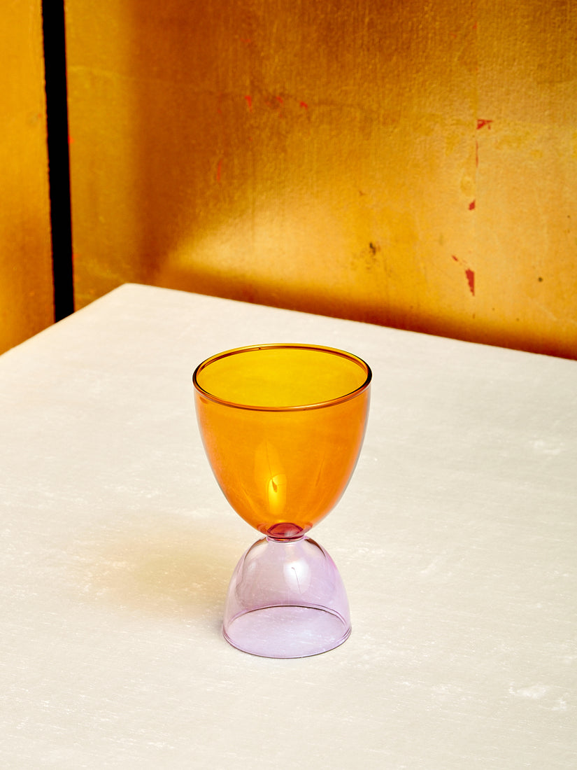An amber top lavender bottom cocktail glass.