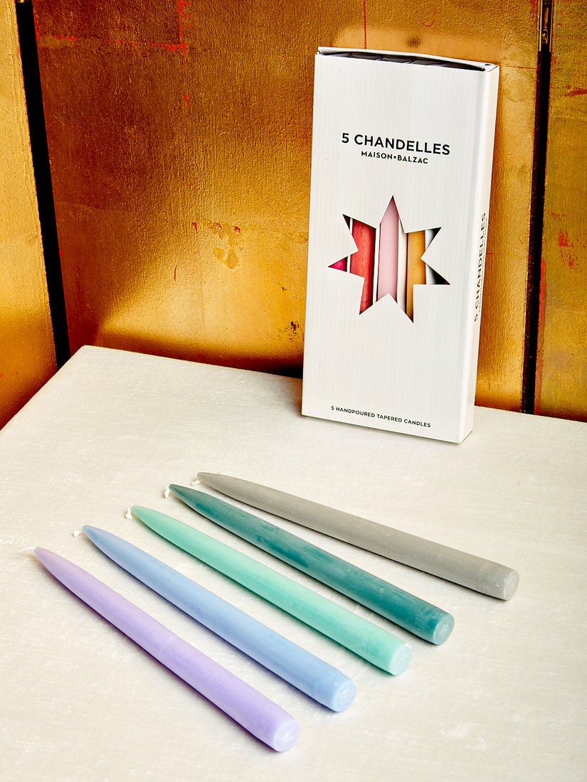 Five taper candles in varying cool tones and a boxed set of five taper candles in varying warm tones.