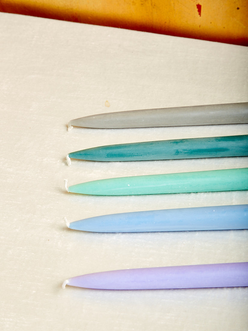 Grey, teal, turquoise, light blue, and lavender taper candles.