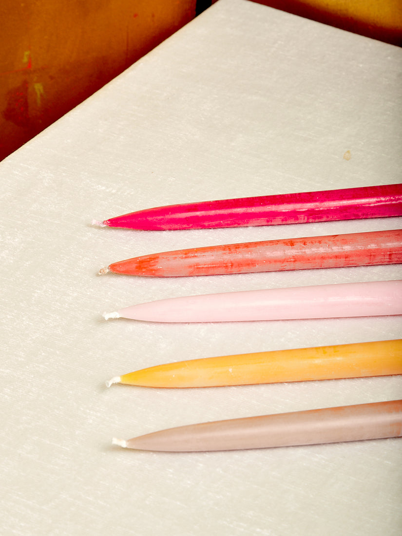 Hot pink, orange, light pink, yellow, and beige taper candles.