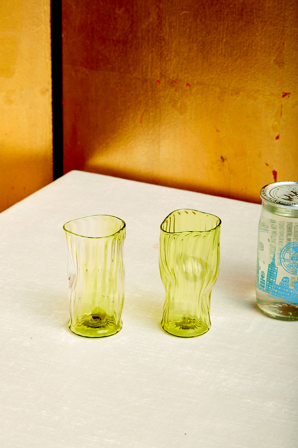 A pair of green sake glasses by Iannazzi Glass.