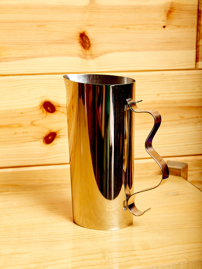 Mirror polished steel pitcher with a wavy handle.