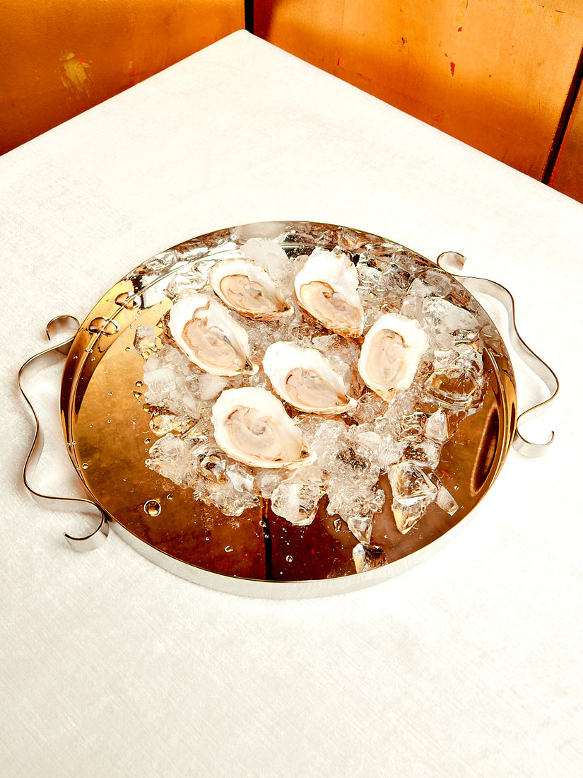 A half dozen oysters sit atop ice in a Squiggle Tray by Sophie Lou Jacobsen.