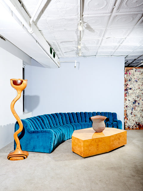 Sculptural Wooden Floor Lamp styled with a blue endless sofa, and burl coffee table.