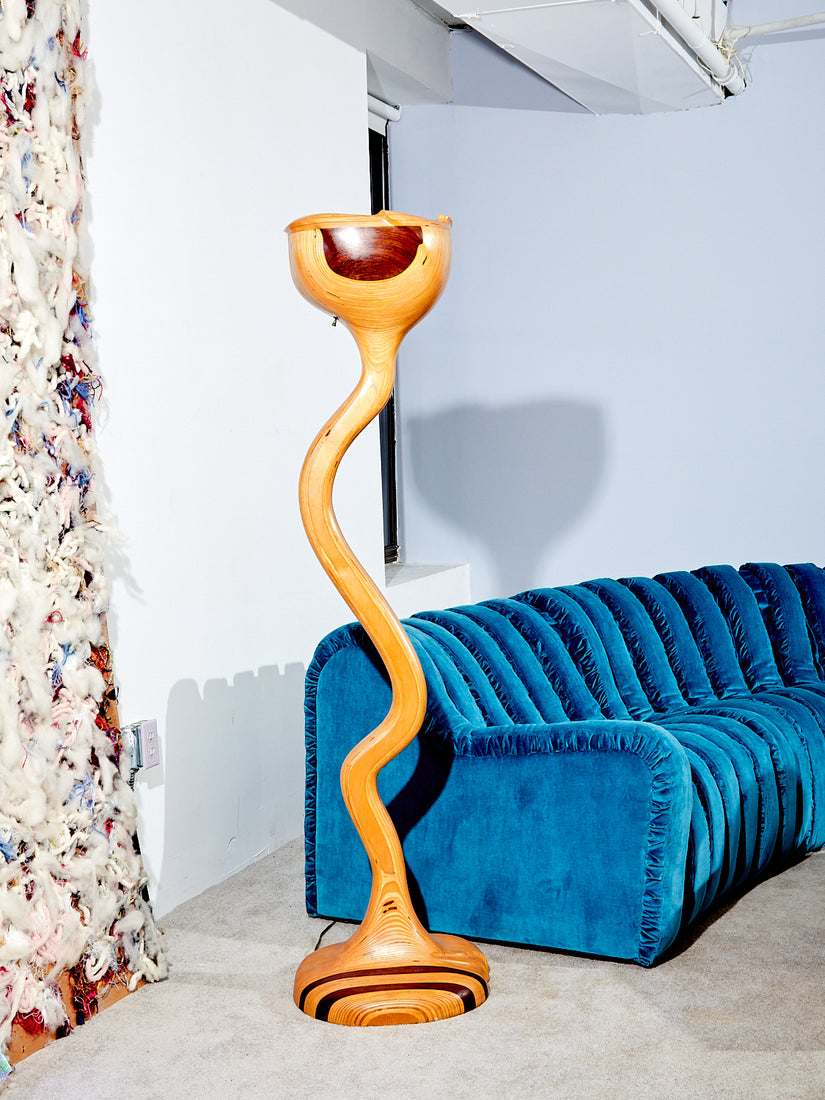Sculptural Wooden Floor Lamp next to a blue endless sofa.