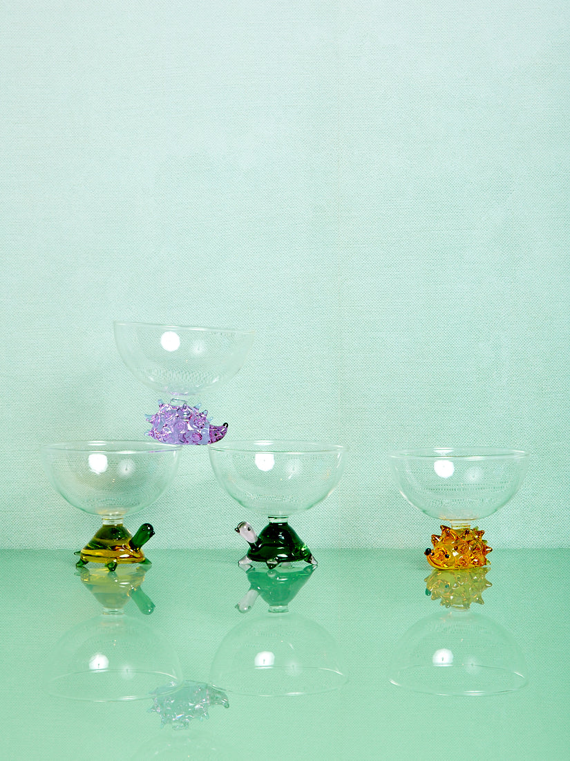 Four bowls that feature a clear dome dish atop a formed glass animal.