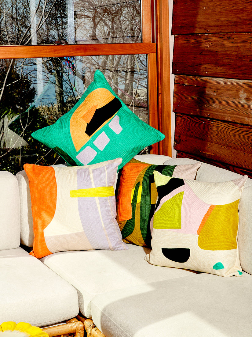 All 4 pillows from Cold Picnic's Delighter Abstract Pillow collection sit in the corner of a white couch.