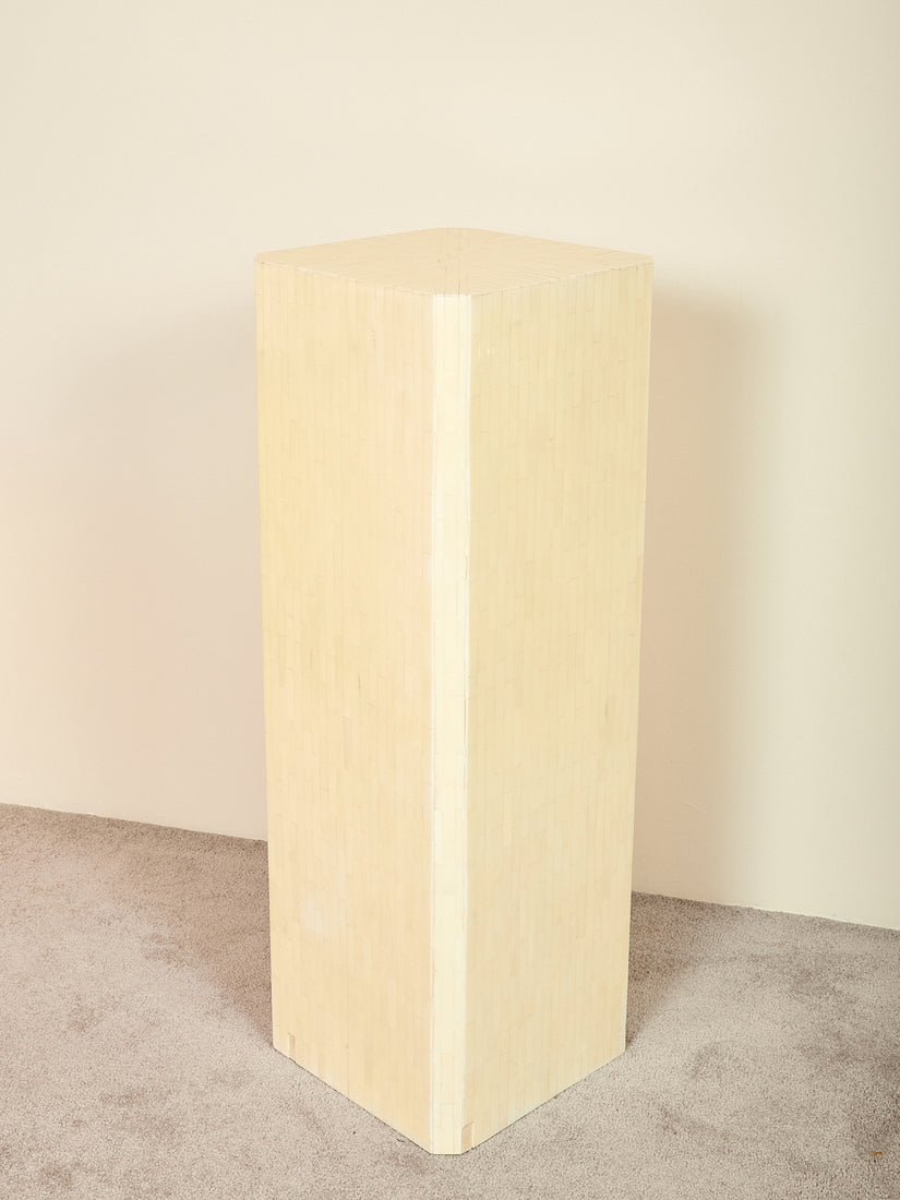 Ivory colored square pedestal with chamfered corners.