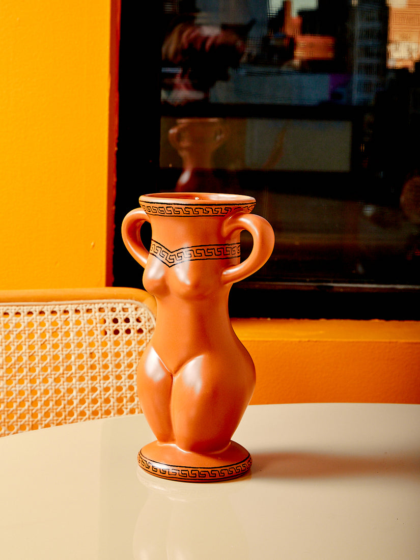 A ceramic vessel in the form of a feminine body that is also a candle.