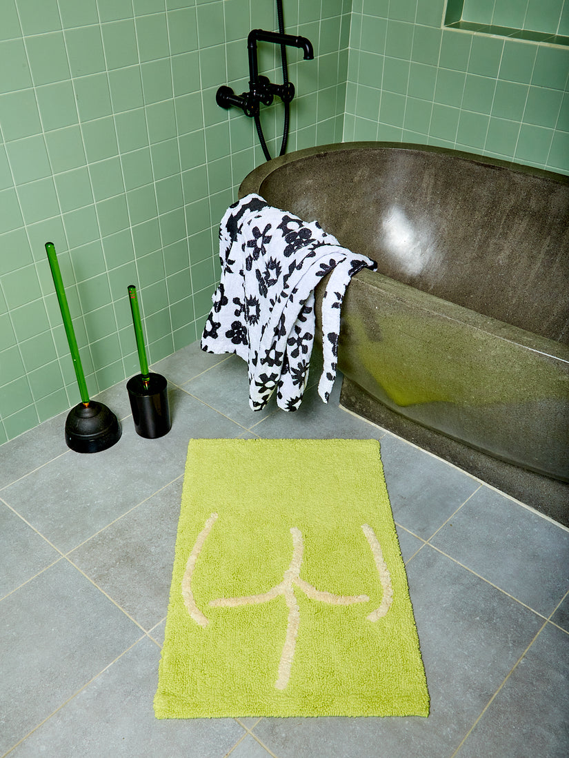 A highlighter Tushy Bath Mat styled with green plunger and toilet brush by Staff.