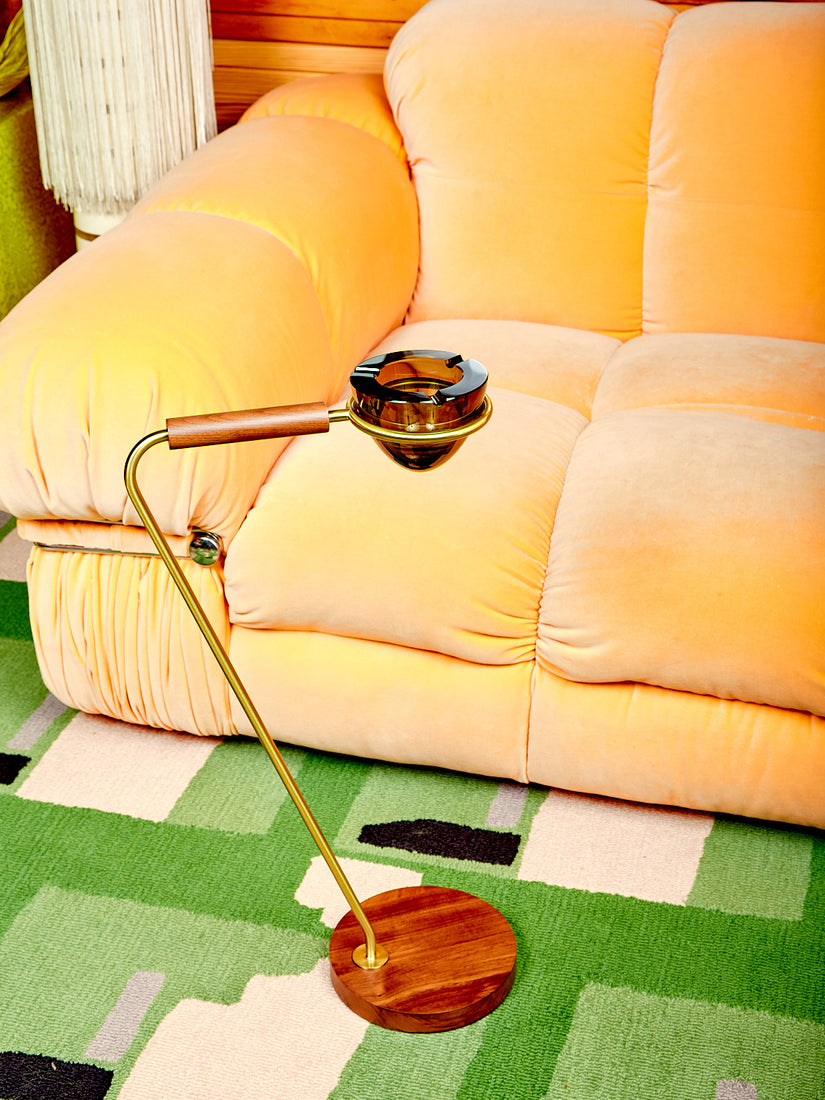 Standing Ashtray by Houseplant sitting on a green Cold Picnic Carpet just in front of an orange velvet sofa.