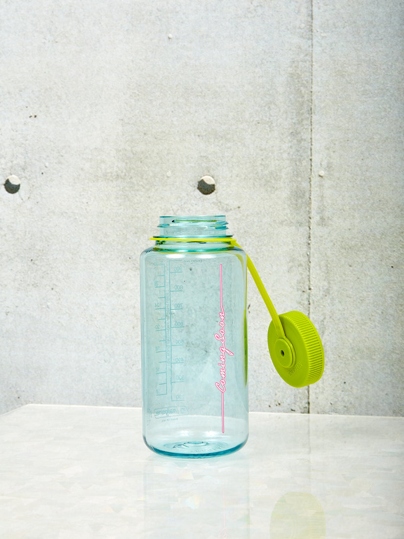A large seafoam Nalgene by Coming Soon with chartreuse lid and pink Coming Soon logo.