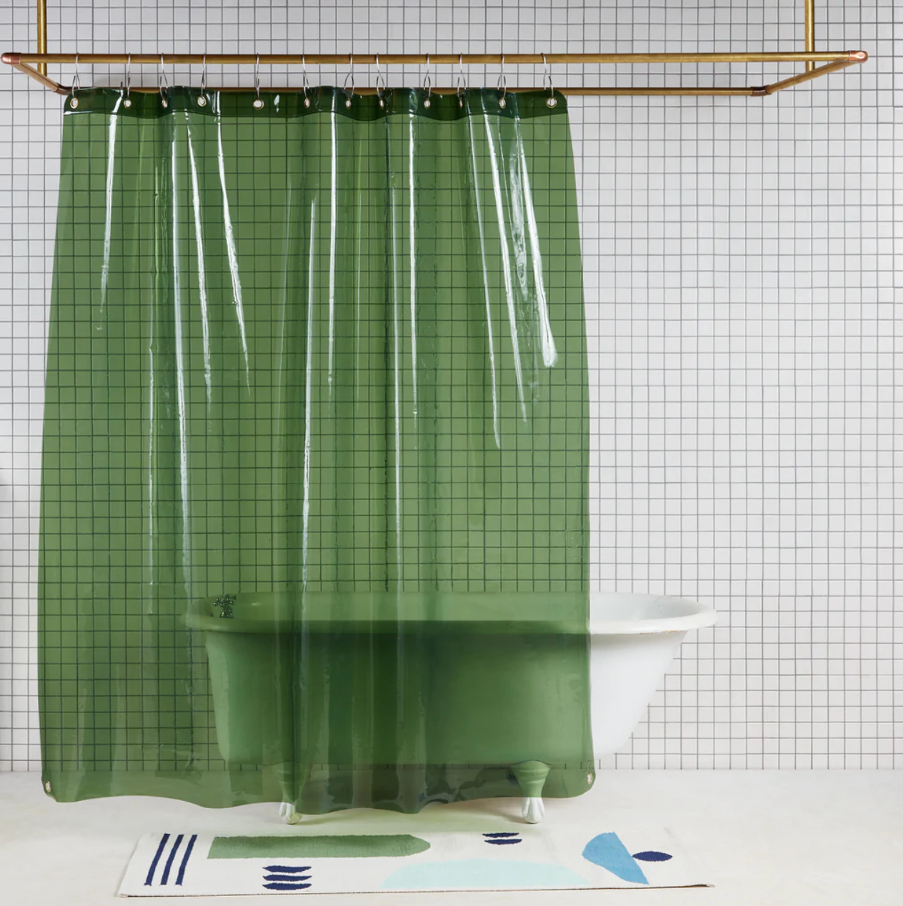 A transparent green Sun Shower curtain by Quiet Town in a white tiled bathroom.