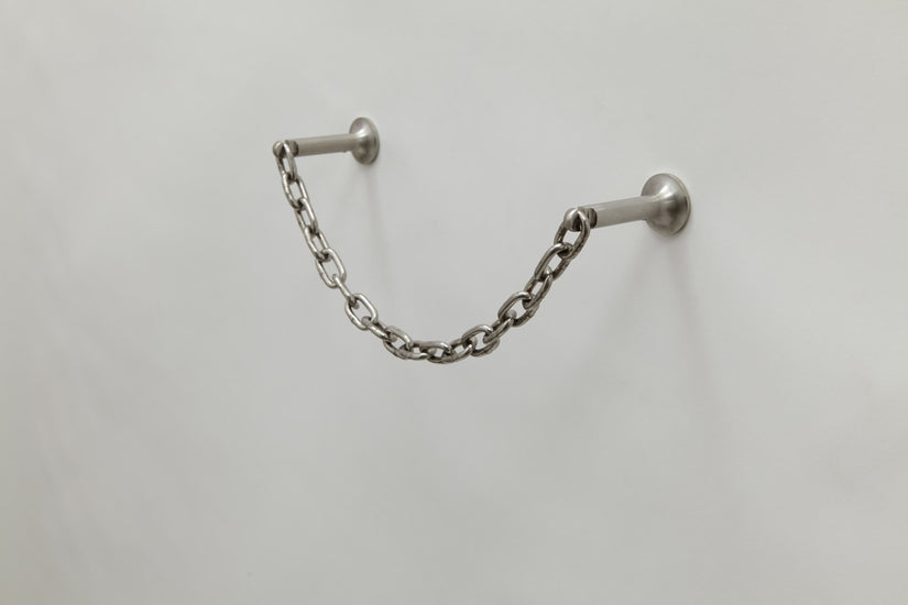 Catena Paper Towel Holder by Chen and Kai. Composed of two stainless steel brackets and thick chainlink.
