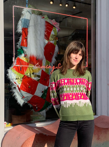 Tessa stand outside of the Coming Soon store wearing the Holiday Sweater.